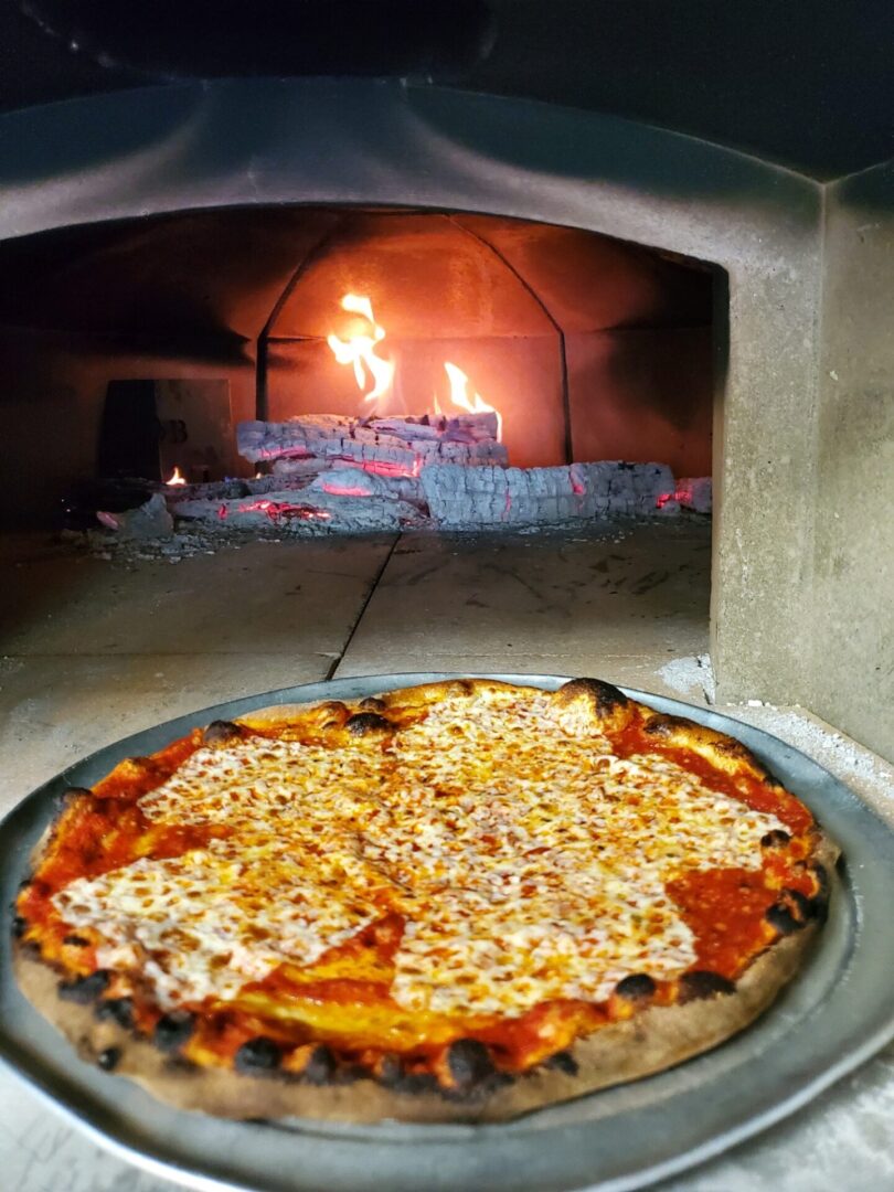 A pizza sitting on top of a pan in front of an oven.